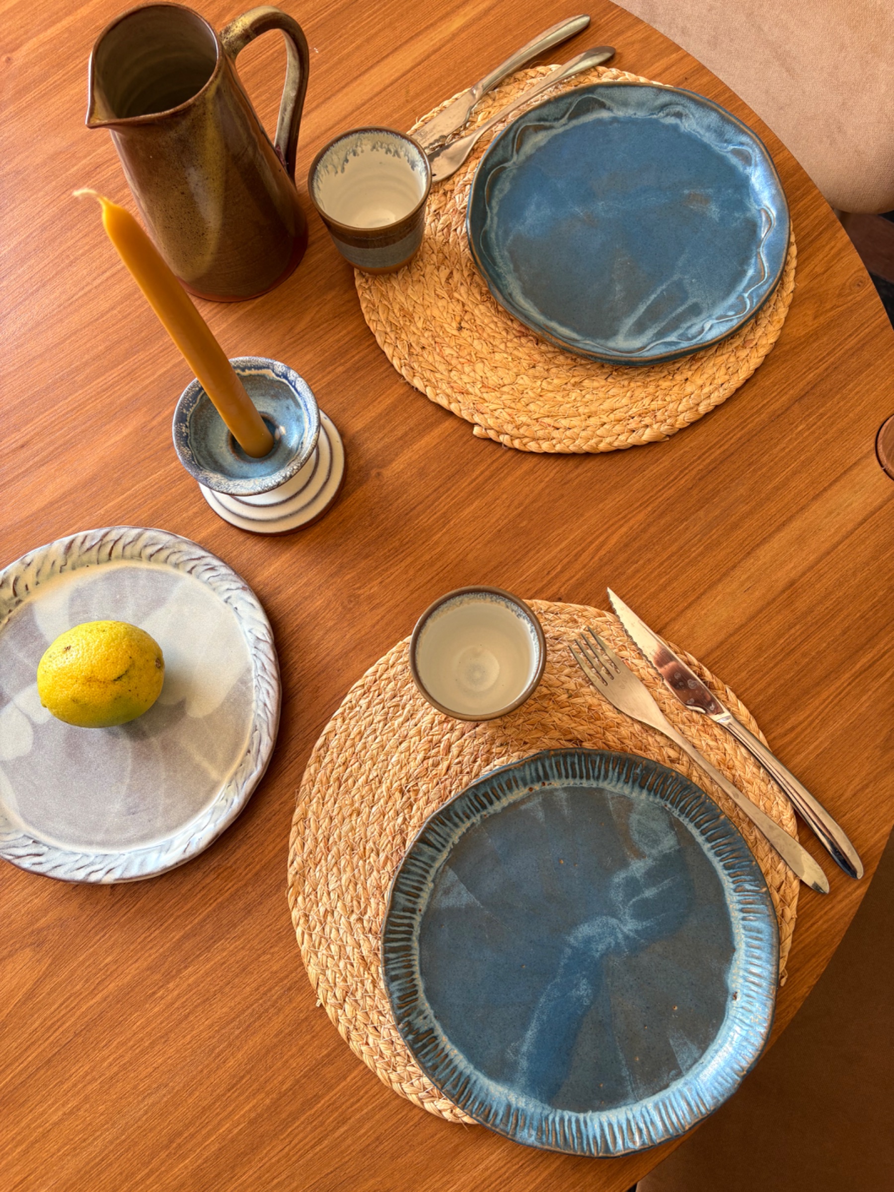 Piezas de gres artesanales sobre mesa de luz natural